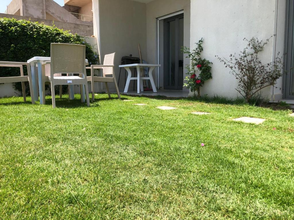 a patio with chairs and a table in the grass at Villa Karim in Nabeul