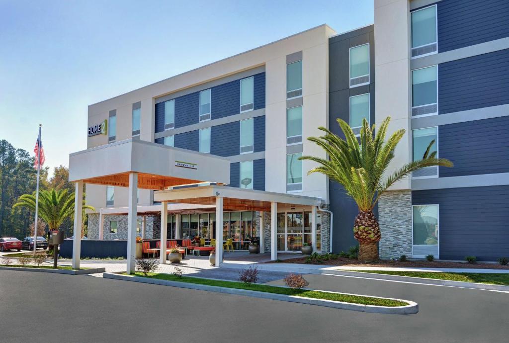 een kantoorgebouw met een palmboom ervoor bij Home2 Suites By Hilton Richmond Hill Savannah I-95 in Richmond Hill