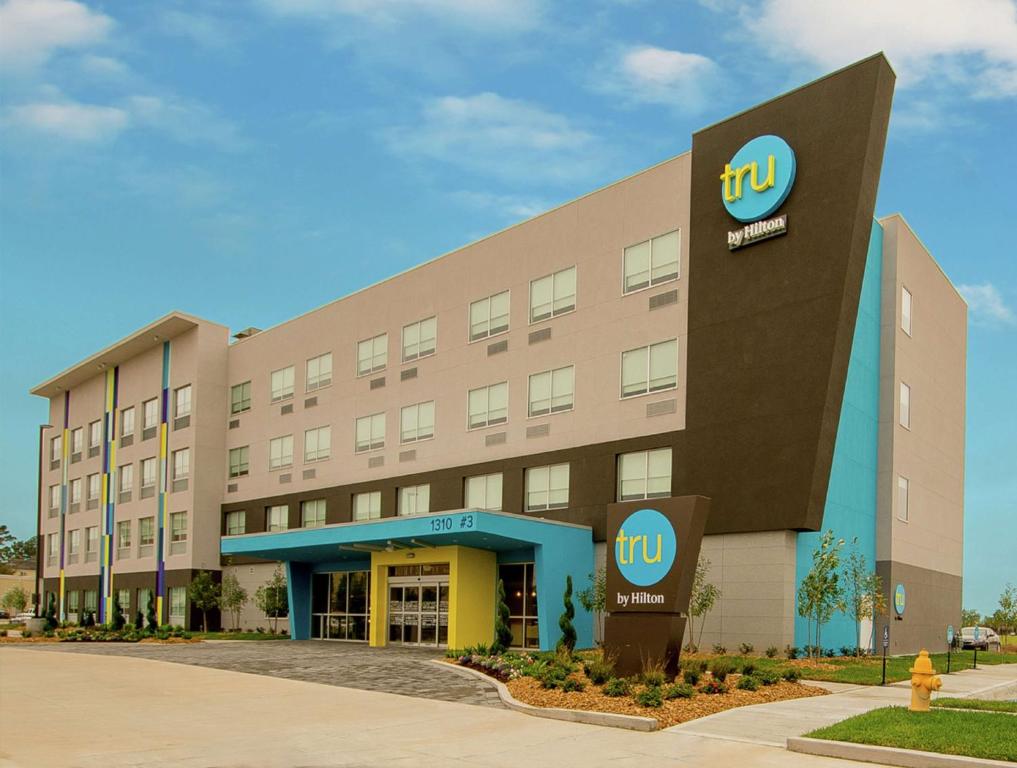 a hotel building with a ups sign in front of it at Tru by Hilton Lafayette River Ranch in Lafayette