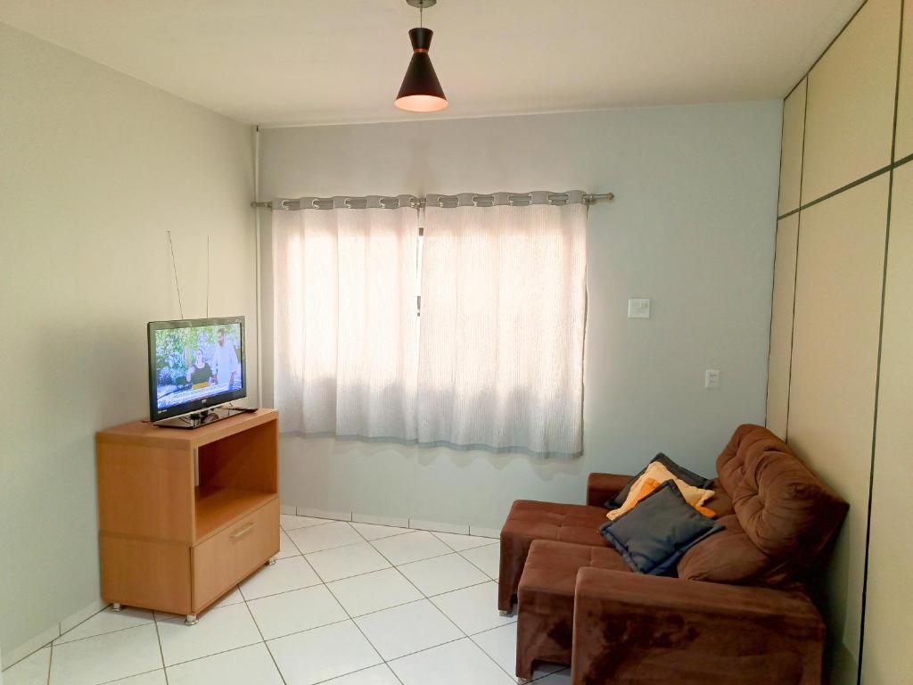 a living room with a couch and a television at Lindo Apto103 em Primavera do Leste in Primavera do Leste