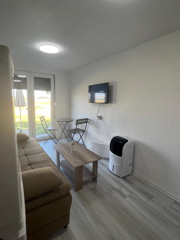 a living room with a couch and a tv on a wall at Apartments Linic in Nin