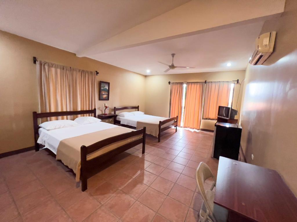 a bedroom with two beds and a television in it at Belen Suites in San Antonio