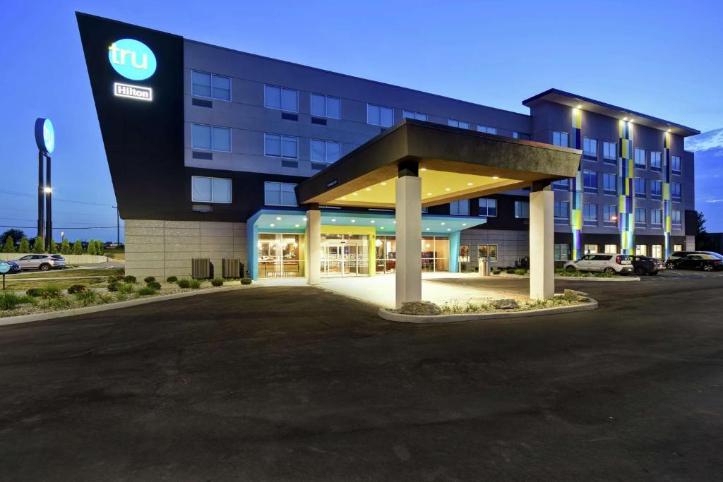 un hotel con un edificio con aparcamiento en Tru By Hilton Fort Wayne, en Fort Wayne