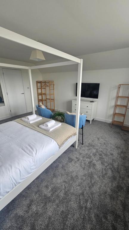 a bedroom with a white bed and a desk at The Cowshed, SAV - Romney Sands Beach House in Littlestone-on-Sea