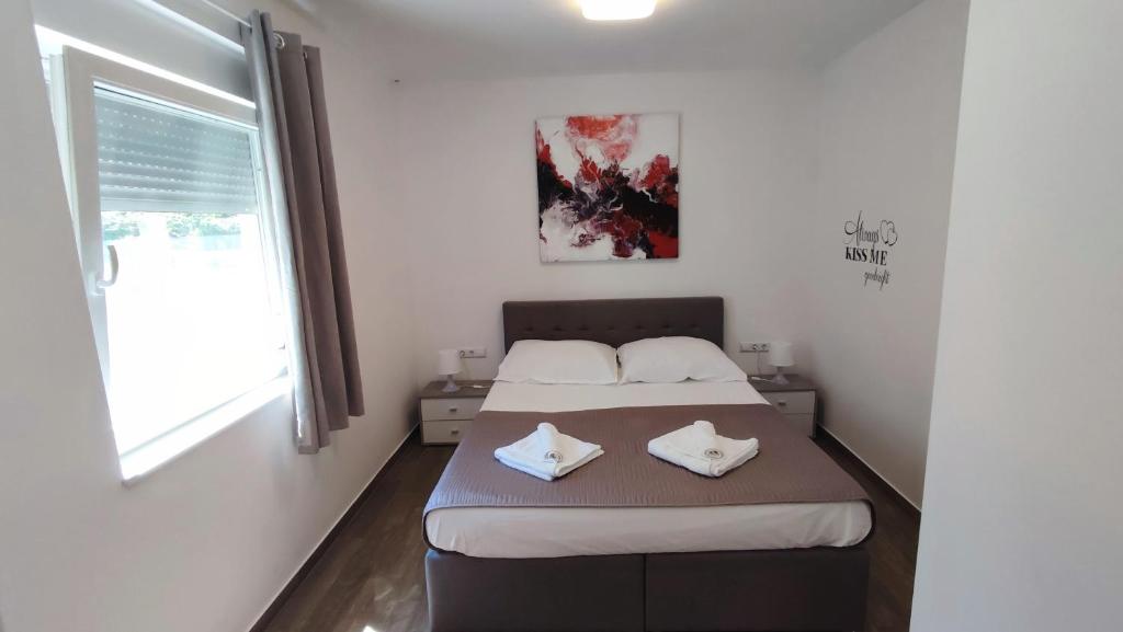 a bedroom with a bed with two towels on it at Holiday Home Aurora in Ližnjan