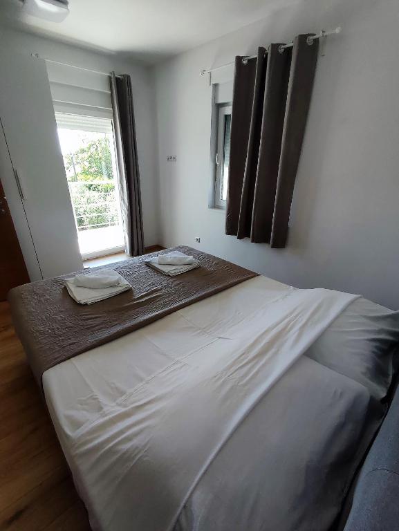a large bed in a bedroom with a window at Holiday Home Aurora in Ližnjan