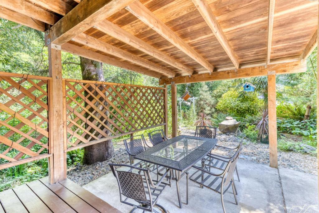 a patio with a table and chairs under a wooden pergola at Sand Dollar Cottage Rockaway - Meredith Lodging in Rockaway Beach