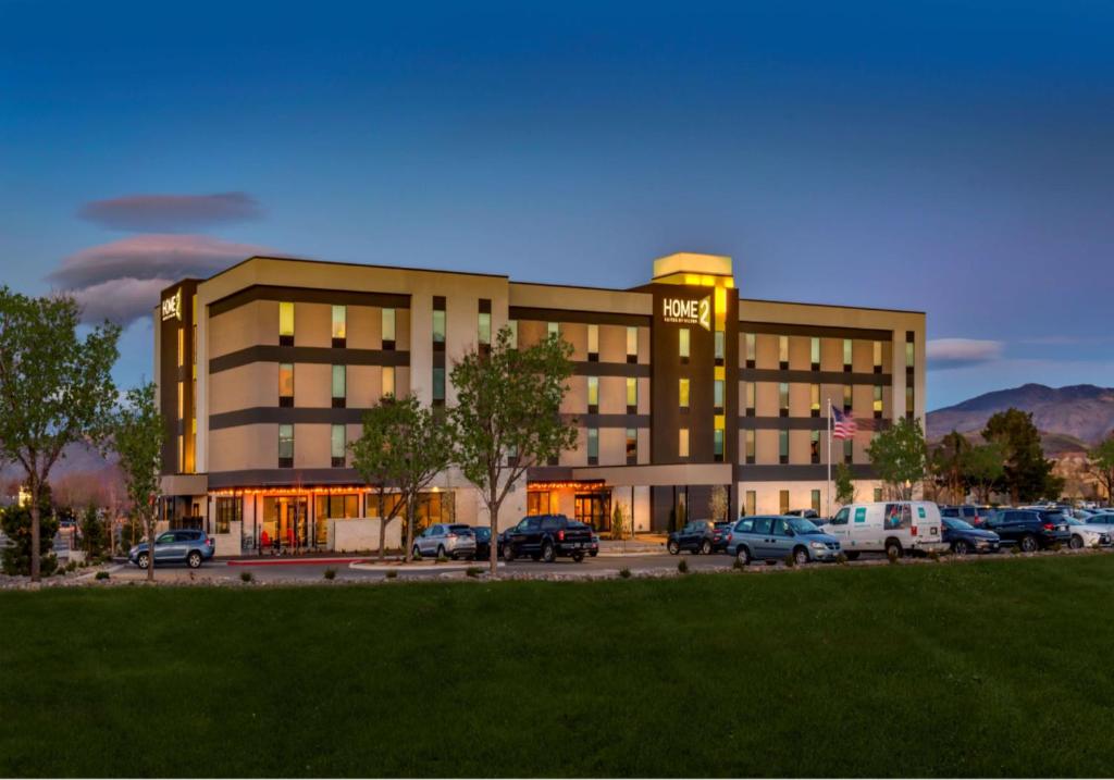 um edifício de hotel com carros estacionados num parque de estacionamento em Home2 Suites By Hilton Reno em Reno