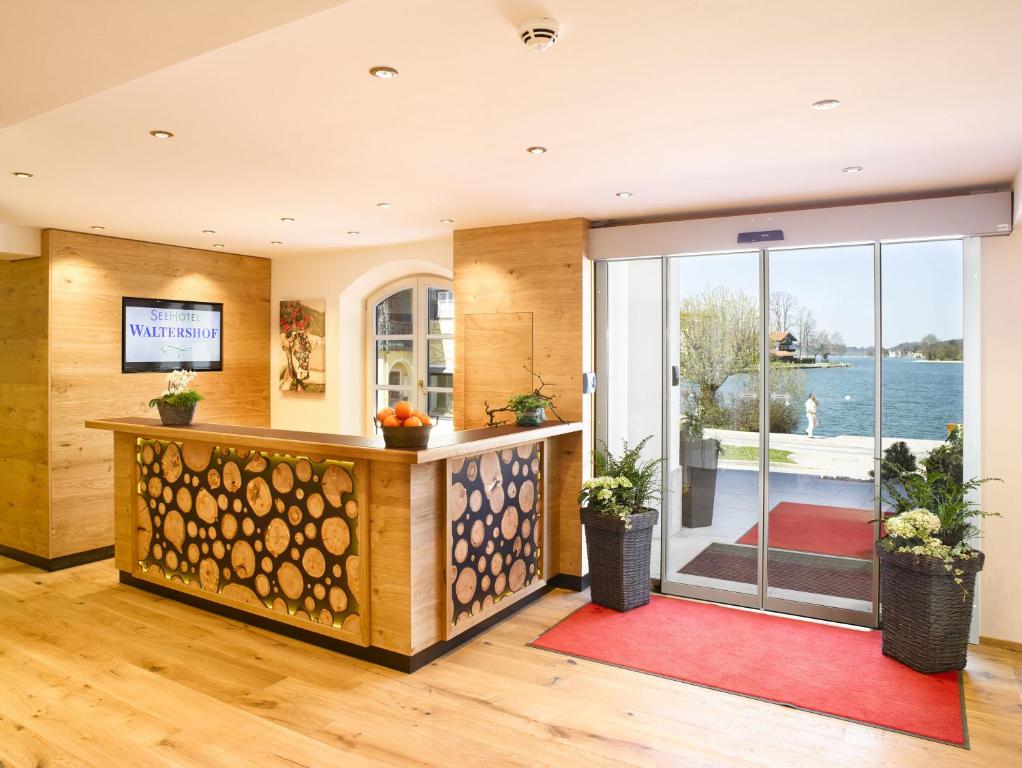 an open living room with a view of the water at Seehotel Waltershof in Rottach-Egern