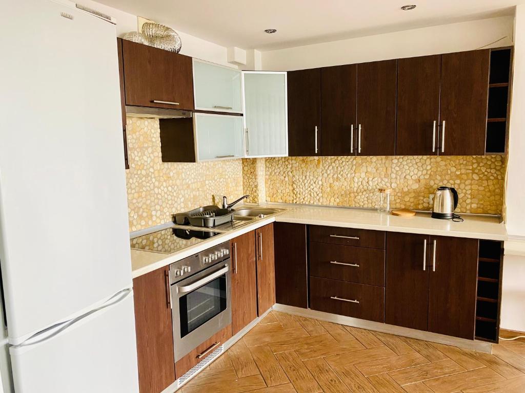 a kitchen with wooden cabinets and stainless steel appliances at Apartament na Orchidei in Bielsko-Biała