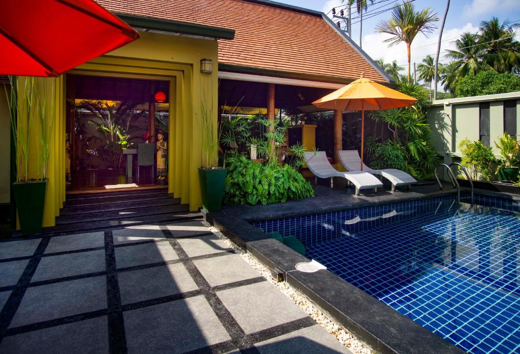 une maison dotée d'une piscine avec des chaises et un parasol dans l'établissement Romantic 1 Bed Villa with Pool - 150 mtrs to beach, à Koh Samui 