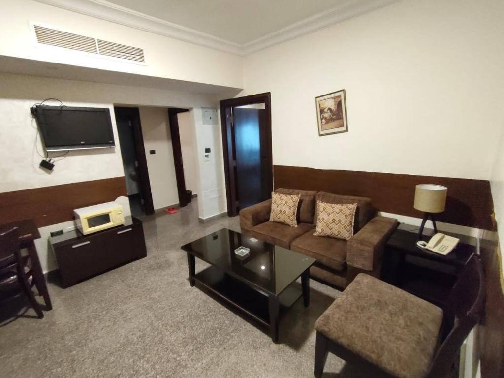 uma sala de estar com um sofá e uma mesa em Tamrah Suites Hotel em Amã