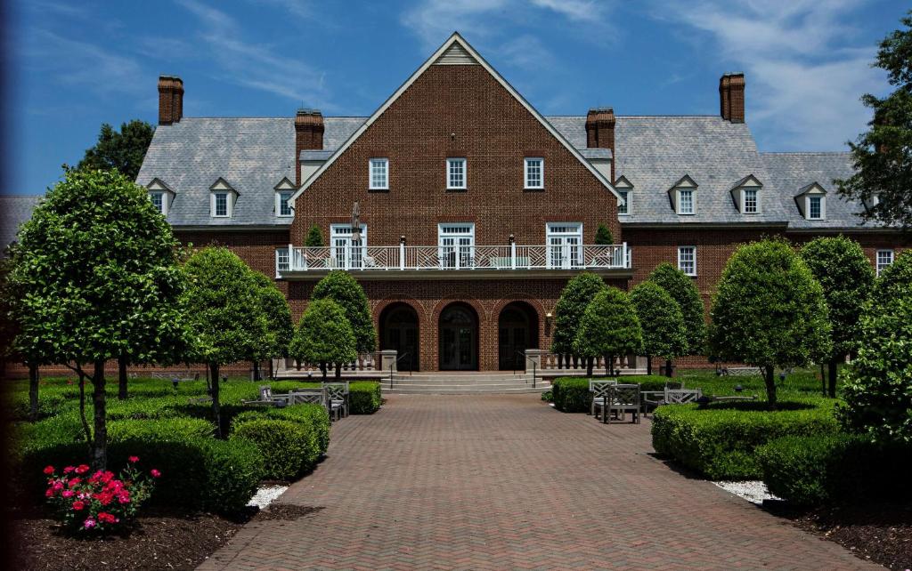 a large brick building with a balcony on top of it at The Founders Inn & Spa Tapestry Collection By Hilton in Virginia Beach