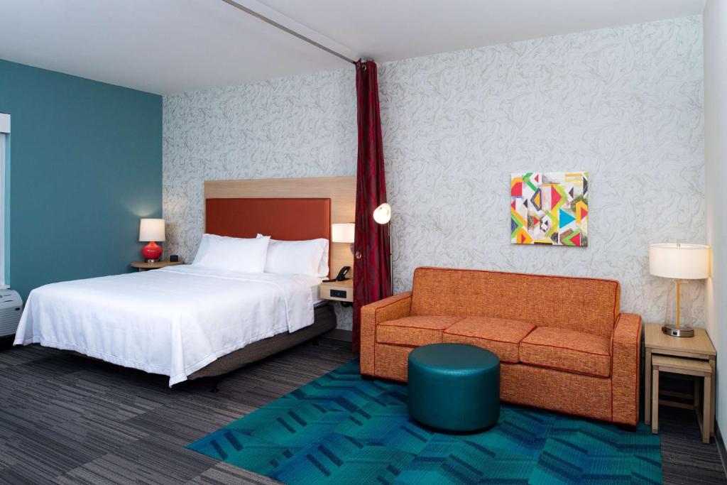 una camera d'albergo con letto e divano di Home2 Suites By Hilton Charlotte Mooresville, Nc a Mooresville