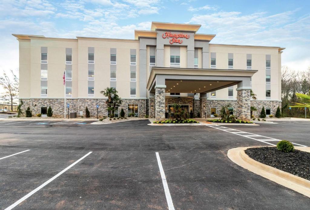 ローカスト・グローブにあるHampton Inn Locust Groveの駐車場付きホテル表面