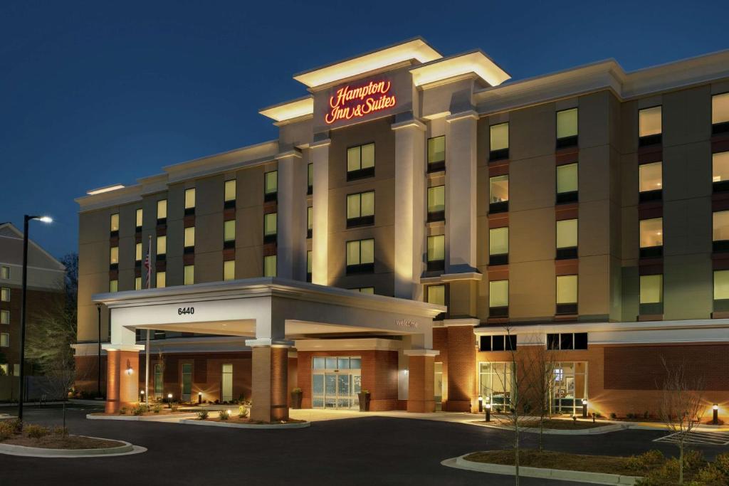 a hotel building with a sign that reads embassy suites at Hampton Inn And Suites By Hilton Johns Creek in Johns Creek