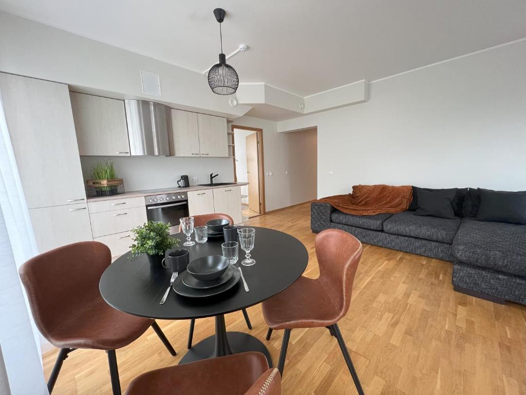 uma cozinha e sala de estar com mesa e cadeiras em Cozy Apartment near City Centre em Tartu