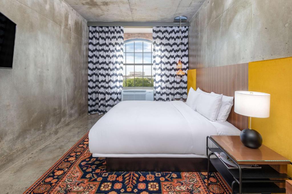 Un dormitorio con una cama grande y una ventana en NYLO Las Colinas Hotel, Tapestry Collection by Hilton en Irving