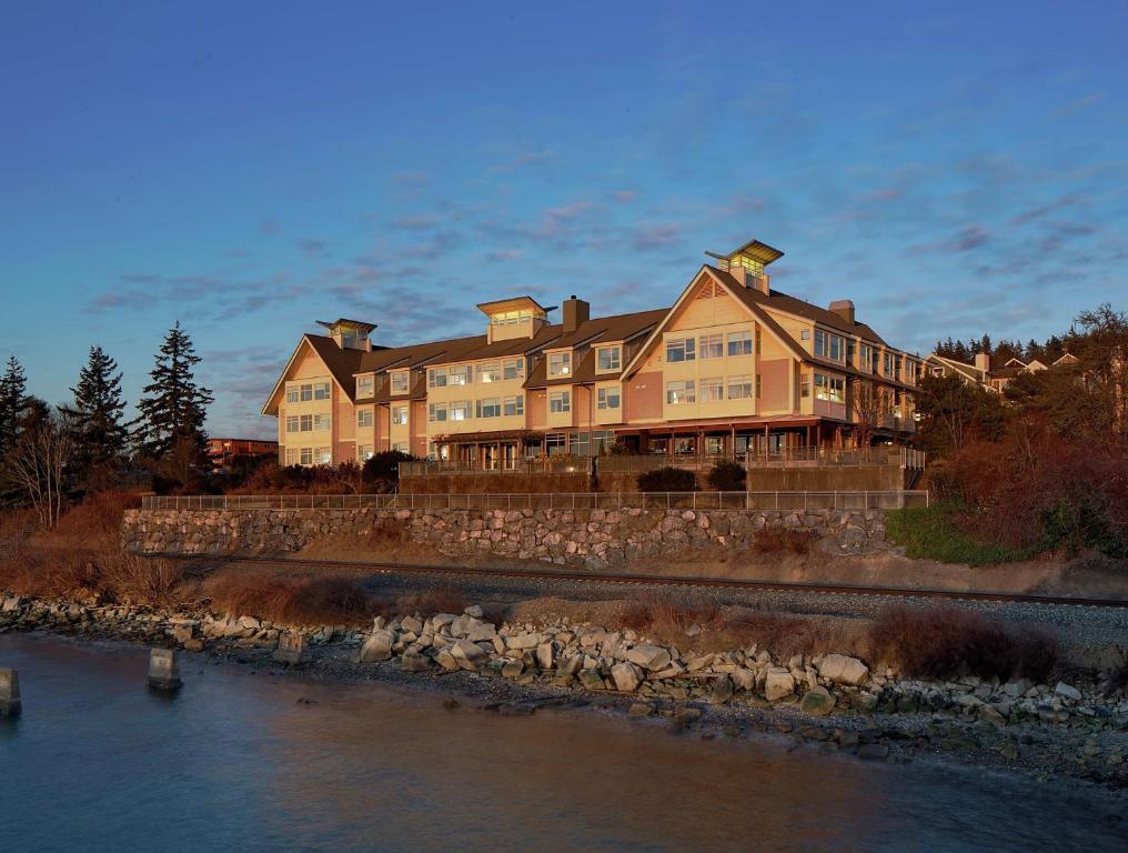 a large house sitting on the side of a river at Chrysalis Inn & Spa Bellingham, Curio Collection by Hilton in Bellingham