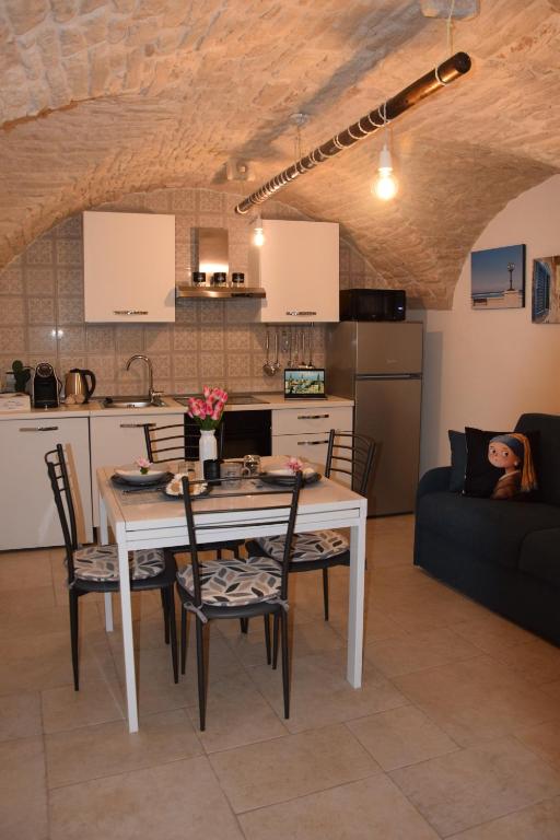 eine Küche und ein Esszimmer mit einem Tisch und Stühlen in der Unterkunft Le Chiavi di San Pietro in Noci