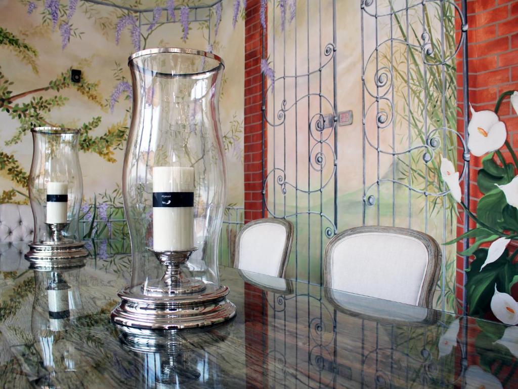 two candles sitting on a table with two chairs at Hotel La Pigna in Marina di Pietrasanta