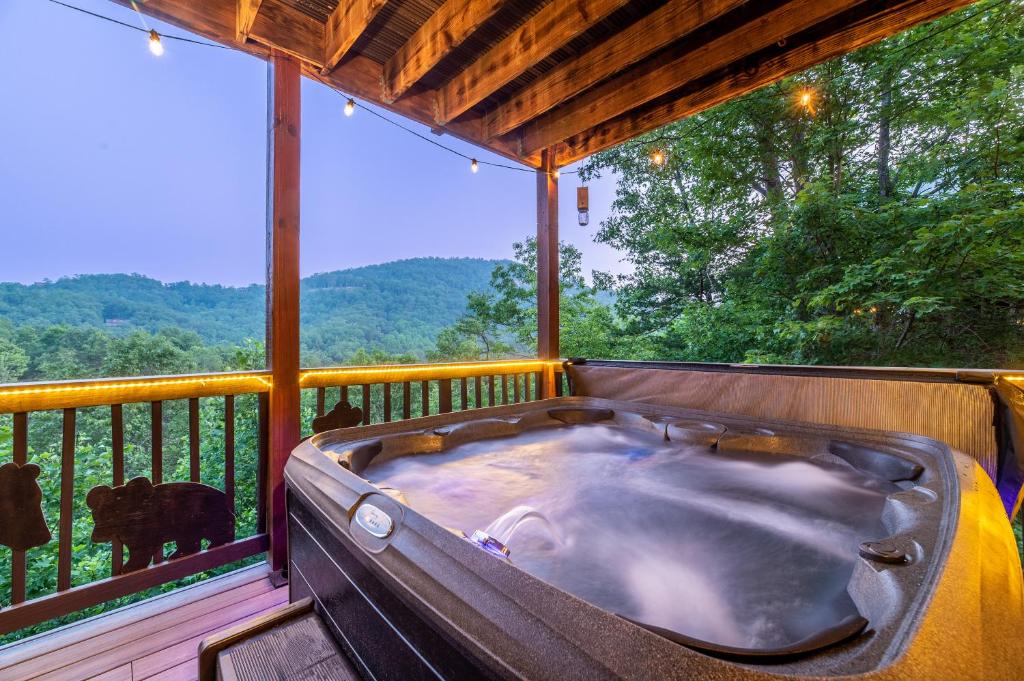 een hot tub op een terras met uitzicht op de bergen bij Summer Special! stunning views, near attractions in Sevierville