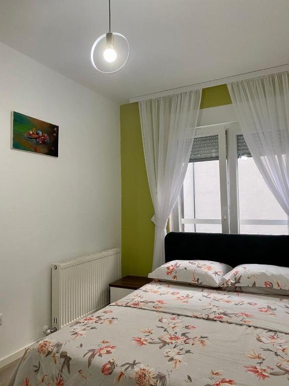 um quarto com uma cama e uma janela em Prishtina Rent Apartment B Street em Pristina