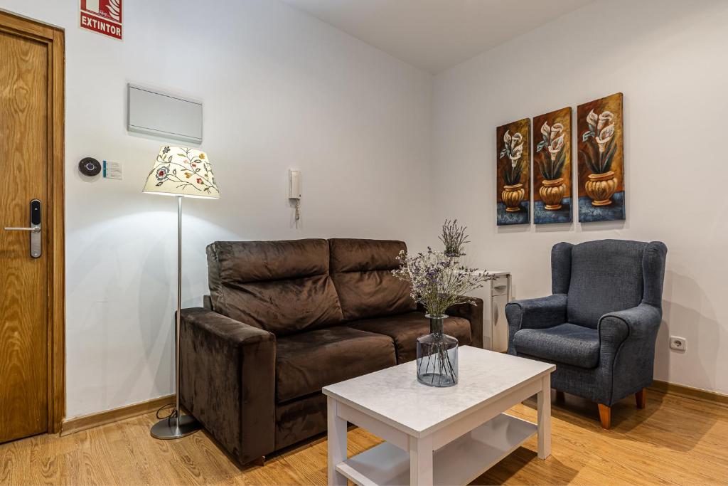 a living room with a couch and a chair and a table at BNBHolder Apartamentos en Sol Confort 7 in Madrid