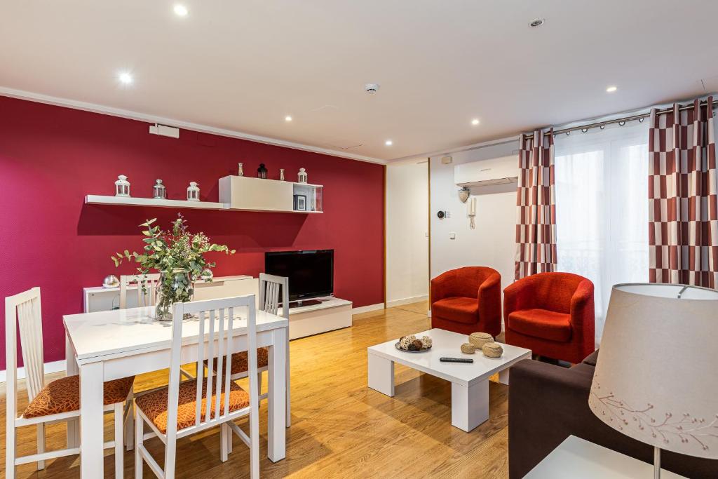 a living room with a red accent wall at BNBHolder Apartamentos en Sol Confort 6 in Madrid