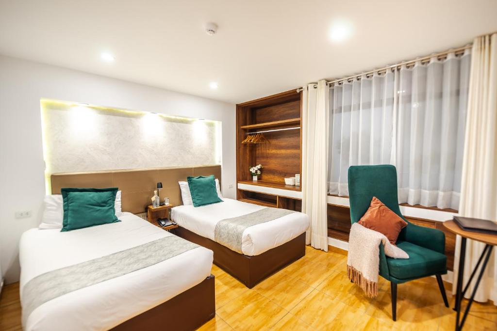 una habitación de hotel con 2 camas y una silla en Hotel Corregidor by Cassana, en Arequipa