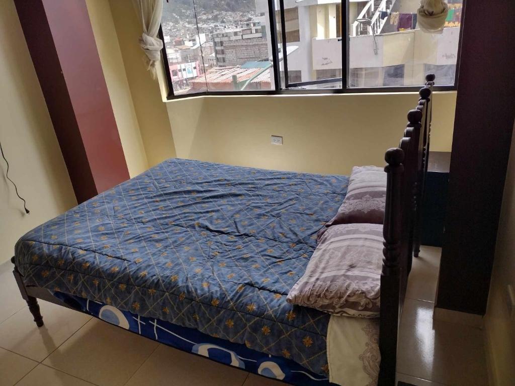 Cama pequeña en habitación con ventana en Ideal para descansar en Ambato