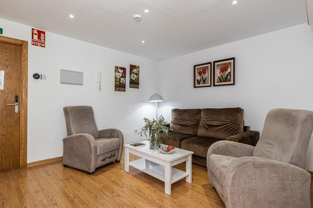 a living room with two chairs and a couch and a table at BNBHolder Apartamentos en Sol Confort 2 in Madrid