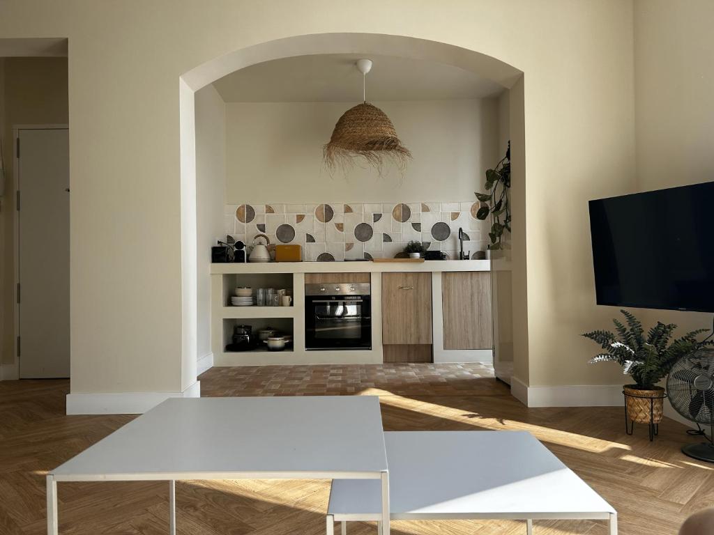 a living room with two white tables and a tv at Apartamento Tarifa Playa Lances in Tarifa