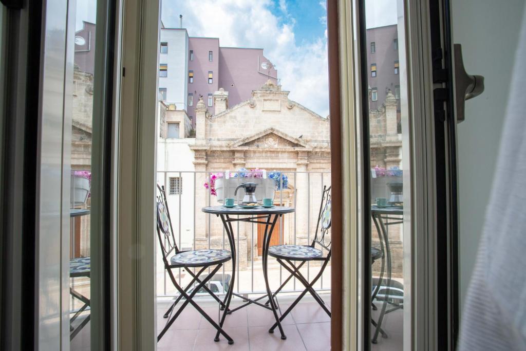 a table and chairs on a balcony with a view of a building at La Finestra su Santa Lucia in Monopoli