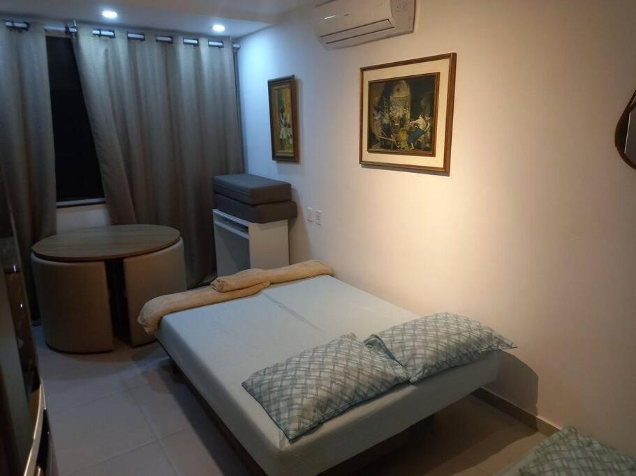 Habitación pequeña con cama y mesa. en Suhcasa Studio Encantador Bairro de Fátima - Lapa, en Río de Janeiro