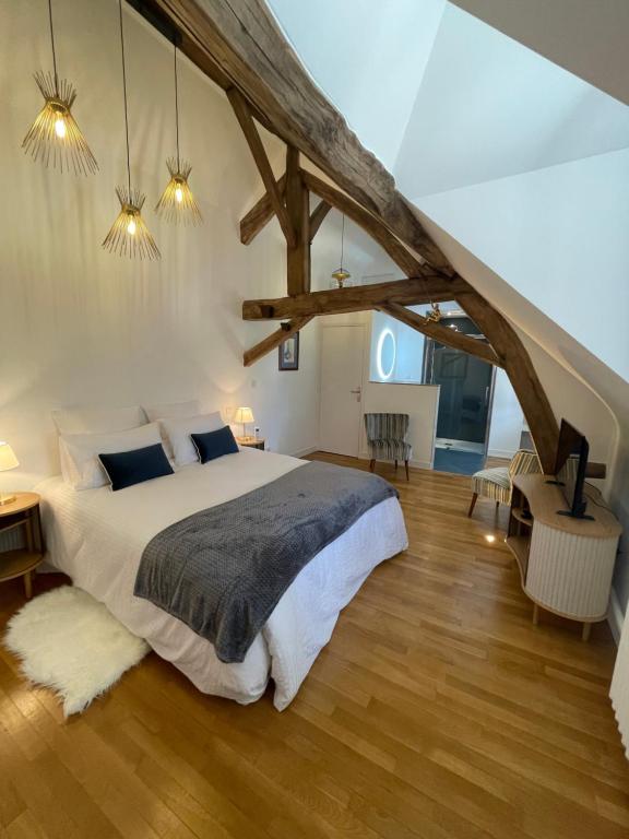 1 dormitorio con 1 cama grande y suelo de madera en Le Clos du Q’hâtre en Cléry-Saint-André