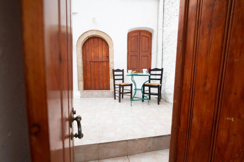 una mesa y sillas en un patio con 2 puertas en MinoaHouse 1 bedroom,3 guests,bath tub & patio, en Ierápetra