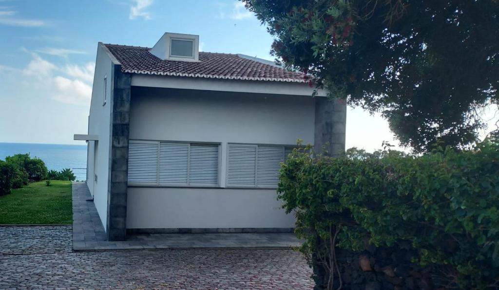 a white house with a view of the ocean at Vivenda Moura, Caloura in Caloura