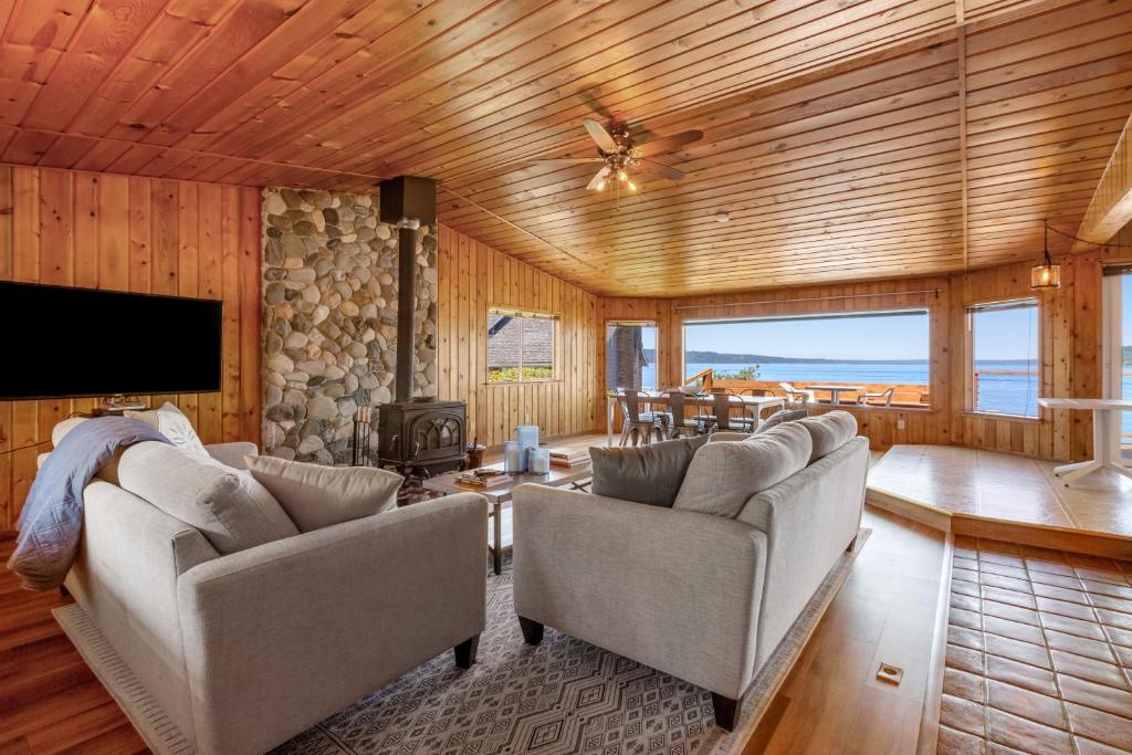 a living room with two couches and a tv at Skiou Point Beach House in Tulalip