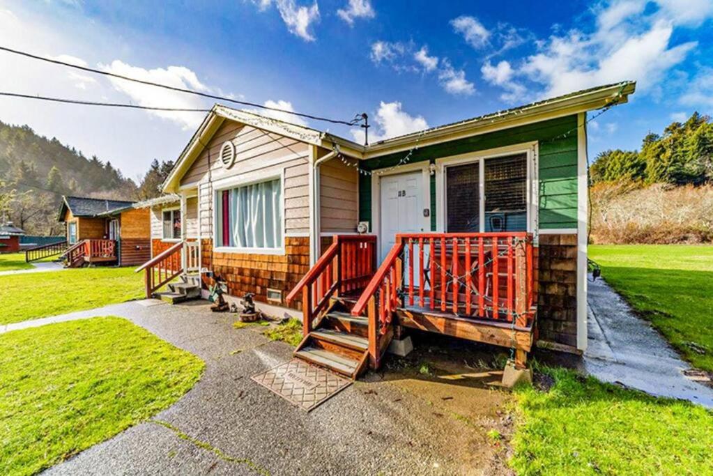 a house with a red railing on the front of it at Elk Meadow Cabins 11B Roosevelt Elk - Single Room in Orick