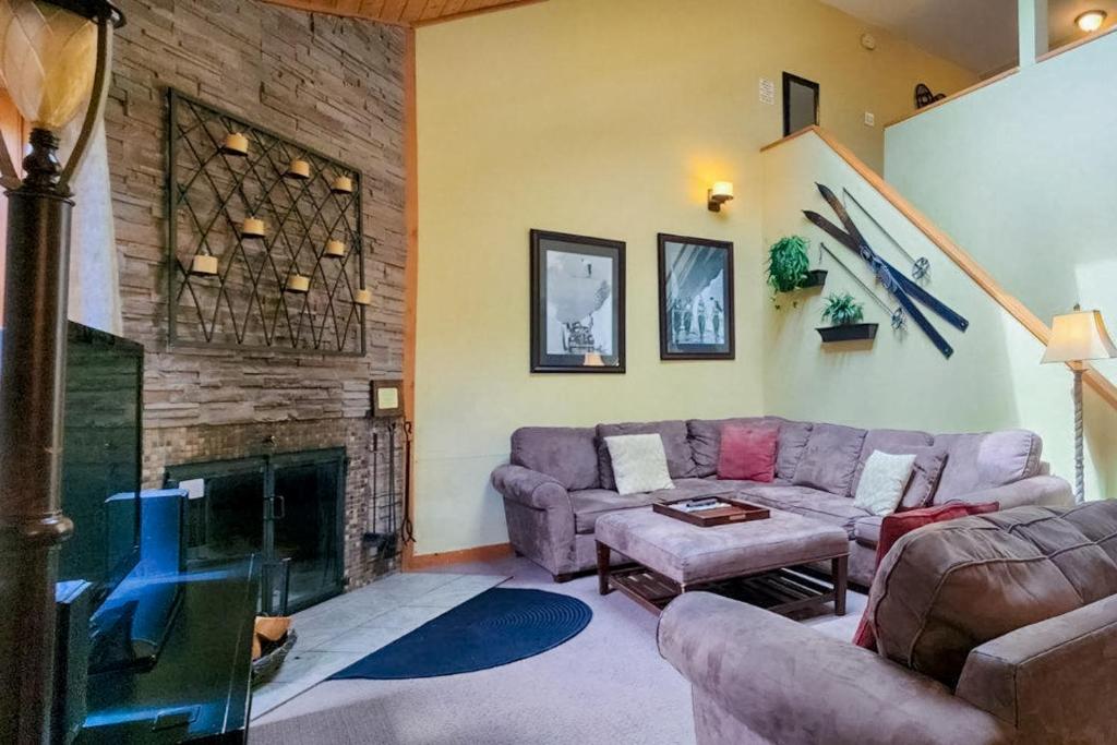 a living room with a couch and a fireplace at Trail Creek 33 in Killington