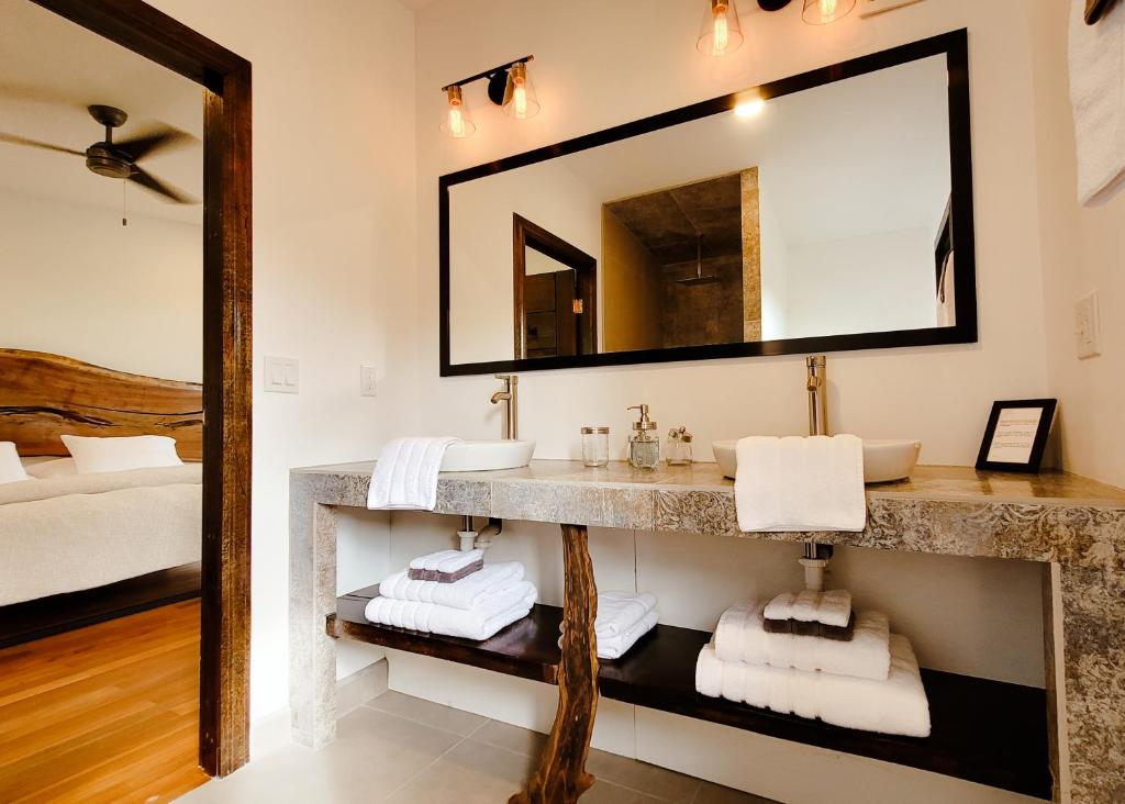 a bathroom with a sink and a mirror at Yumas Riverfront Lodge in San Ignacio