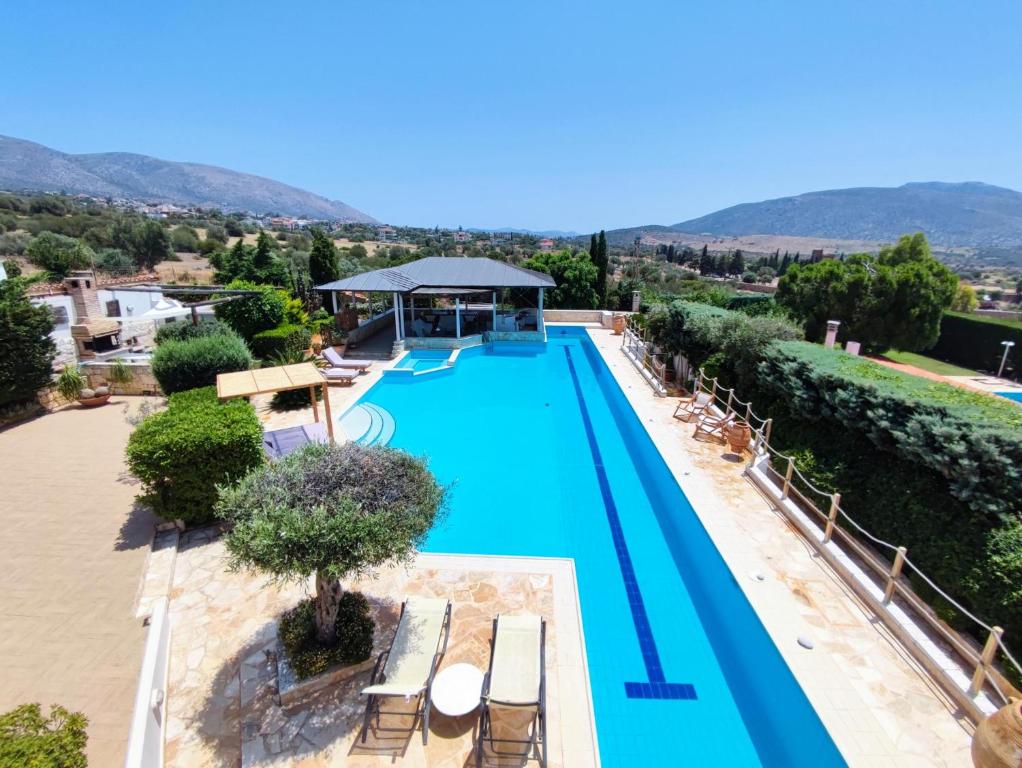 una vista aérea de una piscina con bancos y árboles en Summer Villa Lagonissi en Lagonissi