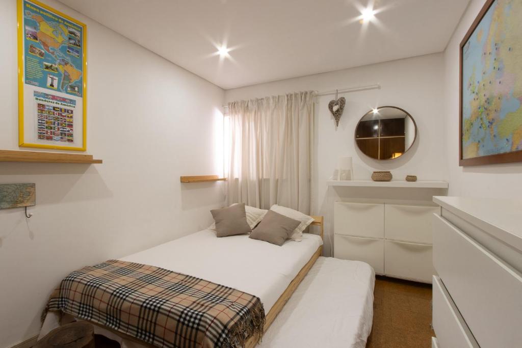 a white bedroom with a bed and a mirror at Watergreenportugal in Ofir
