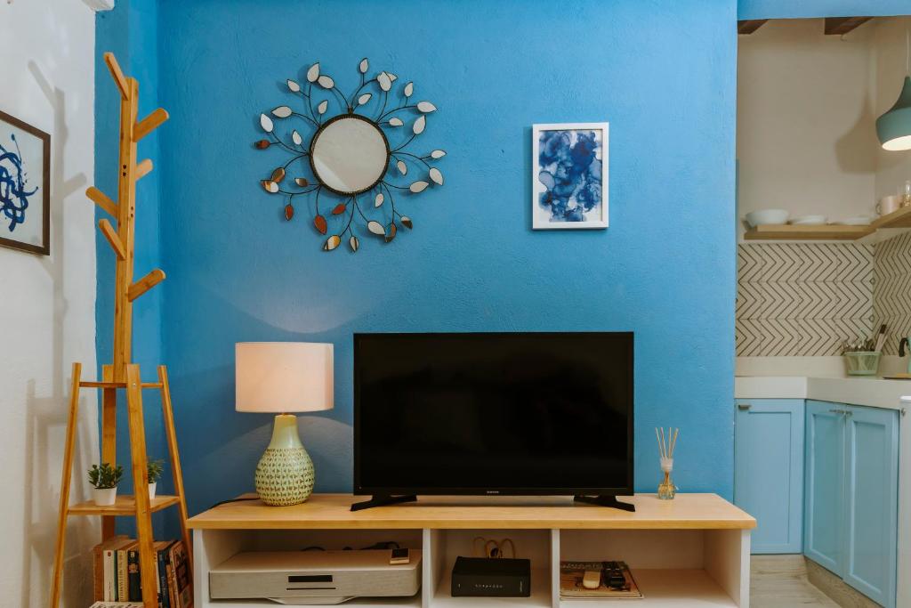sala de estar con TV y pared azul en "Le Petit Bonheur" Cozy studio near beach, en Puerto Vallarta