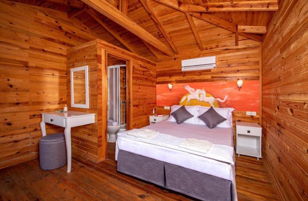 a bedroom with a bed in a wooden cabin at Palmira Selimiye in Marmaris