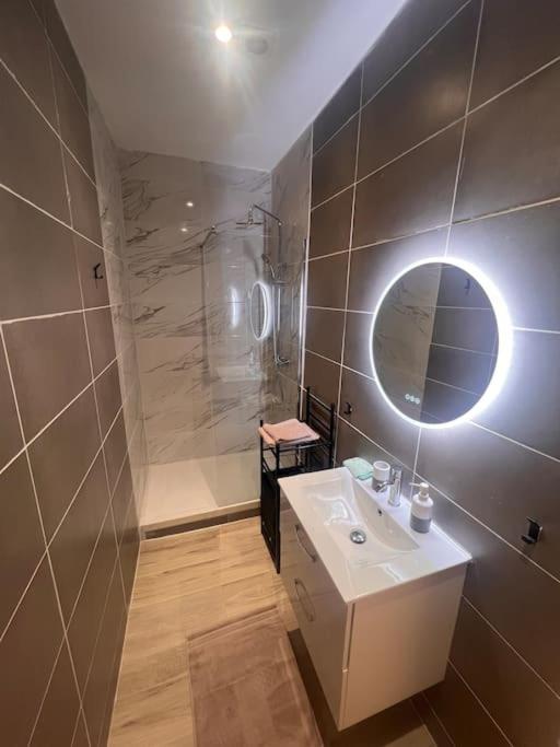 a bathroom with a sink and a shower and a mirror at T2 neuf et moderne climatiser avec Netflix amazon in Marseille