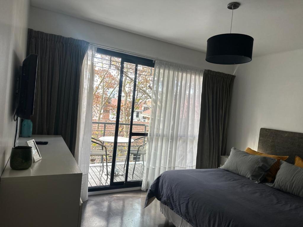 a bedroom with a bed and a large window at Nicaragua 6042 in Buenos Aires