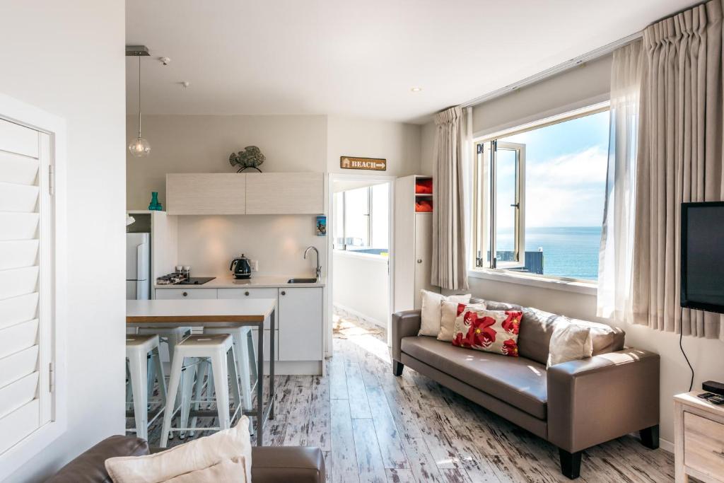 a kitchen and living room with a couch and a table at Oneroa Central - Coast & Country in Oneroa
