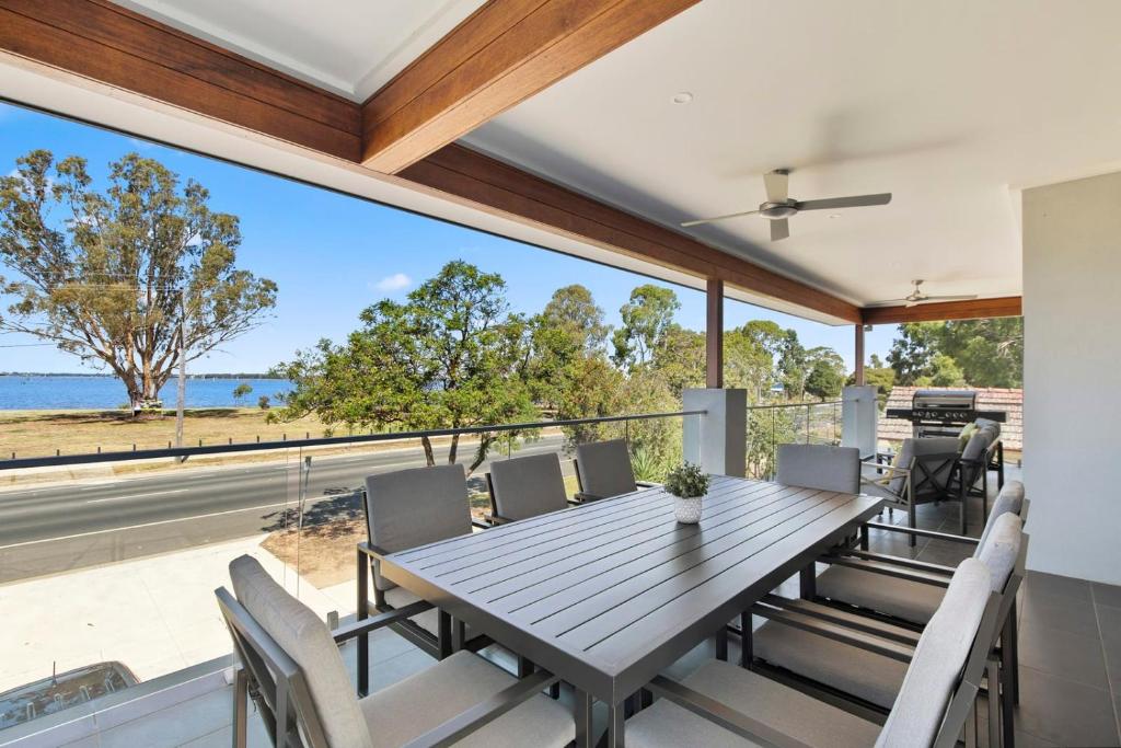 a dining room with a table and chairs and a view of the ocean at NEW - Sunrise Waters Holiday House in Mulwala